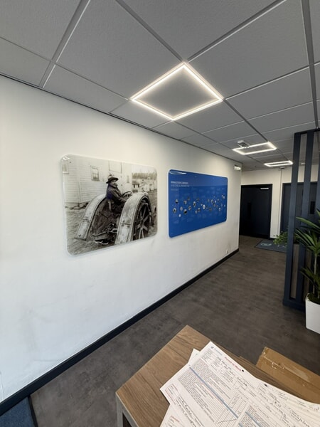 Phase 2 before photo of where 3D foamex logo and text vinyl will be installed. Graphic of Frank Donaldson and a sign of Donaldson company history currently in place, set to be moved.